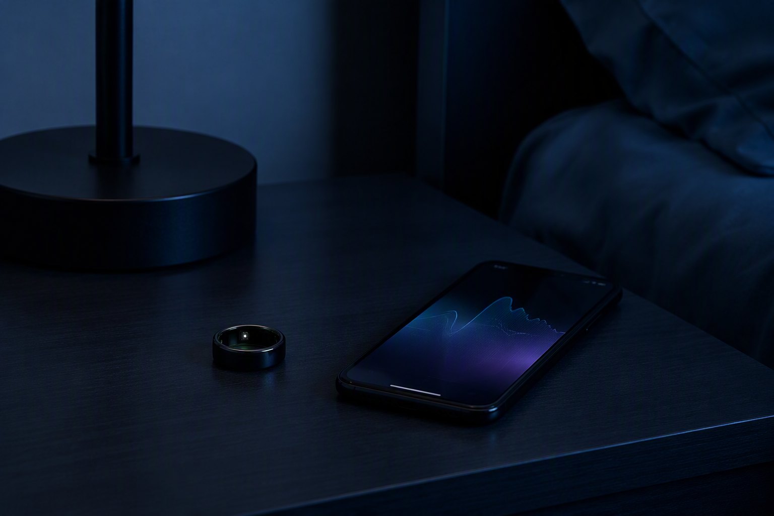 A wearable ring and phone showing a sleep graph on a nightstand